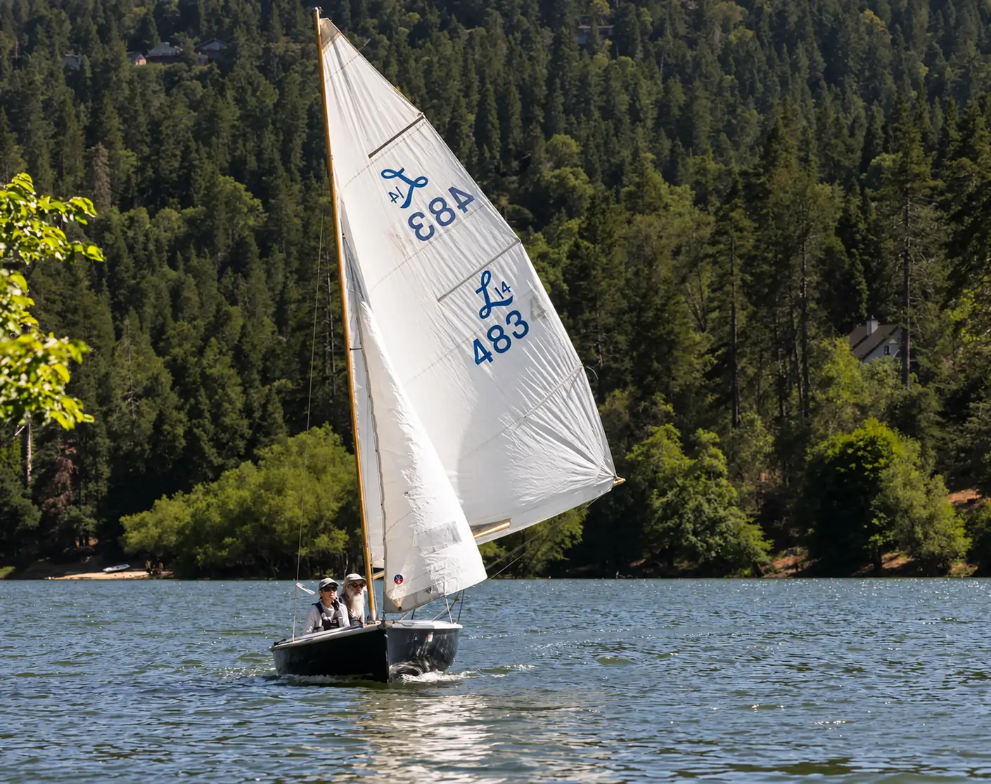 Members sailing a Lido 14 dinghy upwind on Lake Gregory